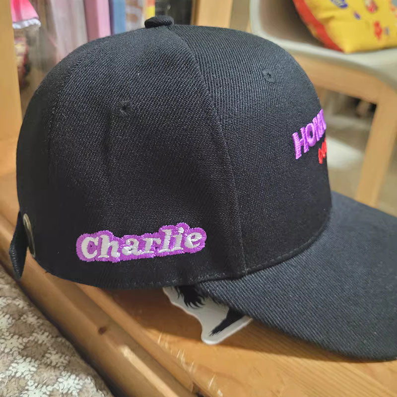 Black baseball cap with an embroidered script logo on the side panel